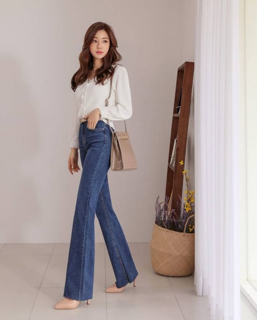 外出前に鏡の前で最終的な服装とメイクのチェックをする女性