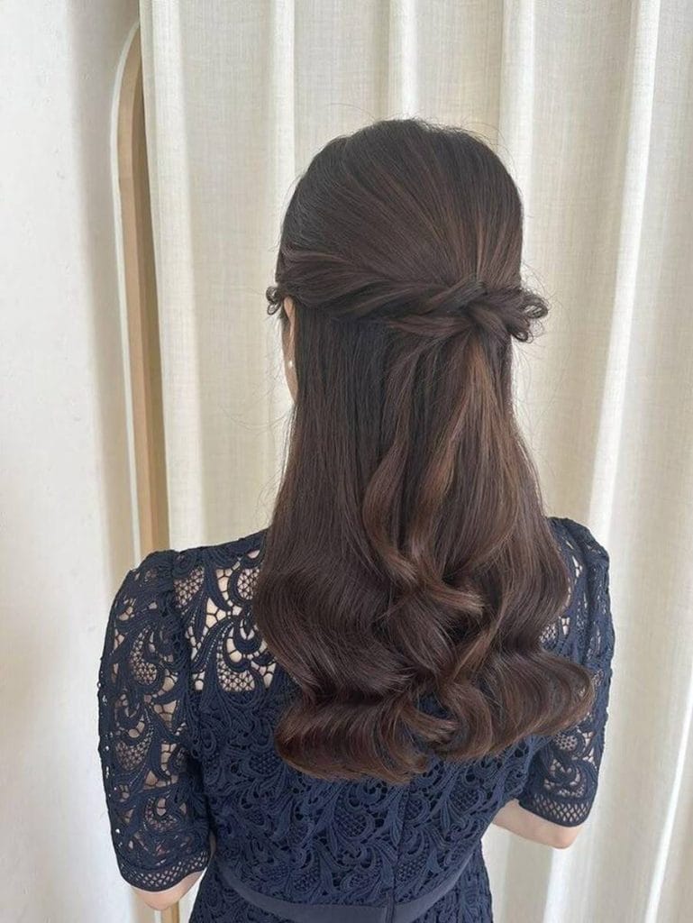 ナチュラルでまとまりのある髪型と清楚なアクセサリーを身につけた女性