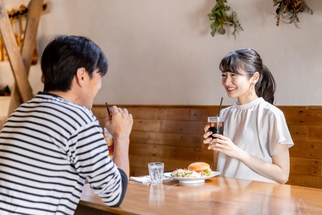カフェでリラックスしながら笑顔で過ごす30代カップル