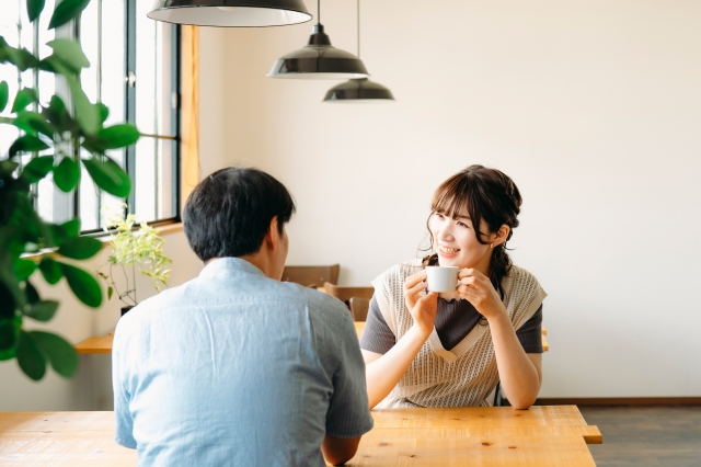 カフェで笑顔で対面し、リラックスした雰囲気で会話を楽しむ30代の男女