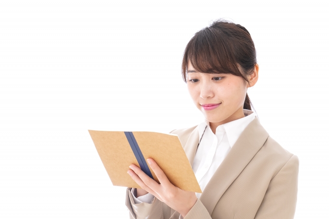 ノートに婚活の予定やデートの作戦を書き込む女性の手元