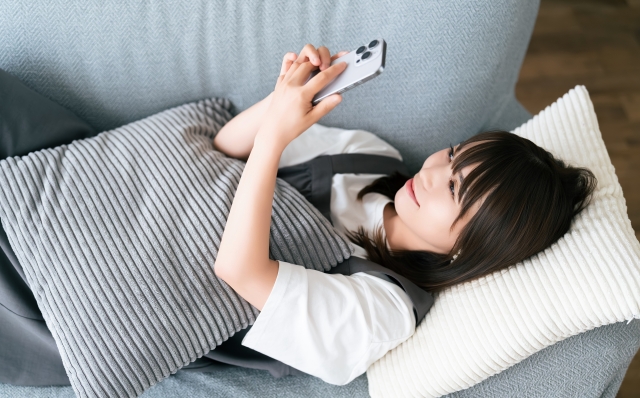 デートを終え、充足感のある表情でスマホを確認する女性